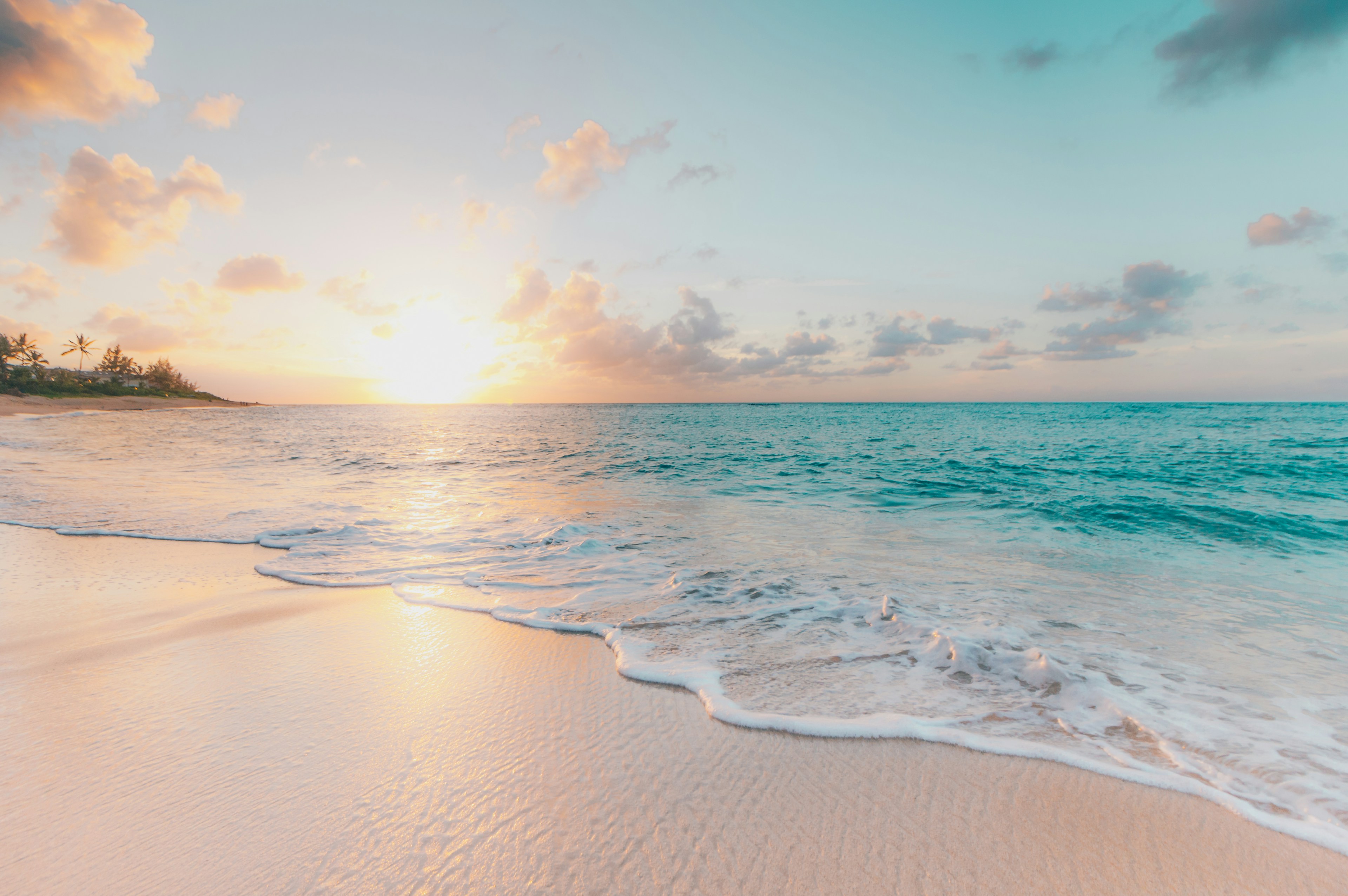 Tropical beach at sunset with turquoise waves and white sand
